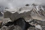 Boulder resting on dirt and ice