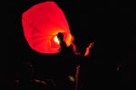 A man lights a candle powered hot air balloon at a festival at Amarbayasgalant